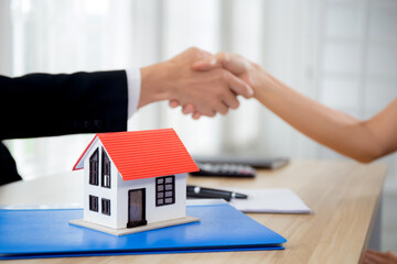 Closeup hands of real estate agent and customer handshake together after agreement together about credit house and insurance, client and consulting of investment about residential, business concept.