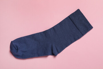 New dark blue sock on pink background, top view