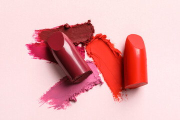 Different lipsticks and smears on light background, top view