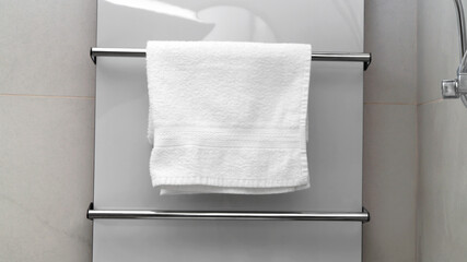Clean towel on heated rail in bathroom