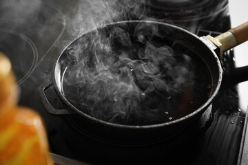 Frying pan with hot used cooking oil on stove