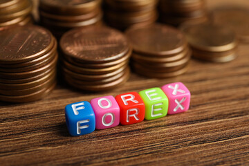 Word Forex made of colorful cubes with letters and stacked coins on wooden table, closeup