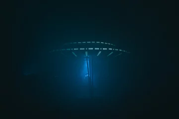 Schilderijen op glas Alien ship UFO in fog at night in blue light. The alien ship landed on the ground. © bodnarphoto
