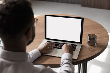 Young man using laptop computer with blank empty mockup screen. Business man working at office....