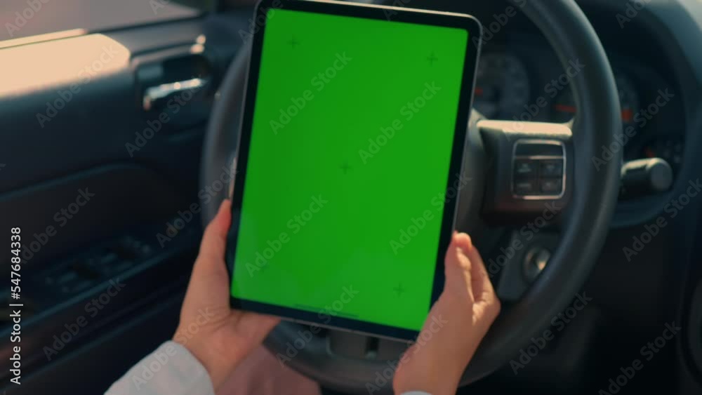 Aufkleber driver in automobile holding digital tablet with green screen person using technology during driving