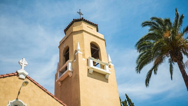 Low angle shot of the Congregational United Church of Christ with palm tree and blue sky