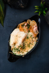 Pancakes with ham and cheese sauce in a cast-iron bowl.