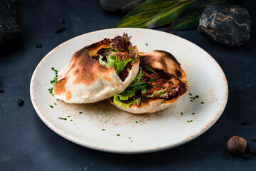 Pita with sweet and sour fried chicken, arugula, lettuce and greens.