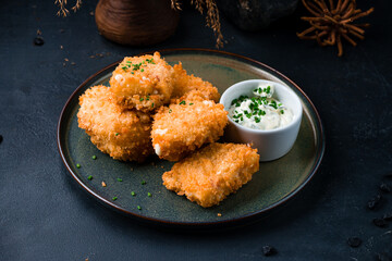 Fried chicken nuggets with sauce and green onions.