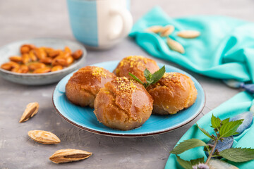 Traditional turkish dessert sekerpare with almonds and honey on gray concrete, side view, selective focus.