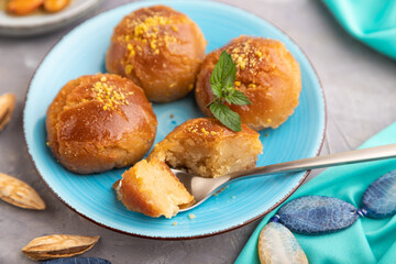 Traditional turkish dessert sekerpare with almonds and honey on gray concrete, side view, selective focus.