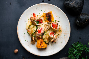 Lunch chicken rolls with baked peppers, mashed potatoes, zucchini slices, corn and herbs.