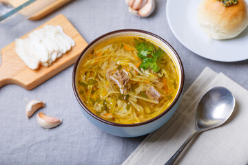Shchi with pampushki (buns) and lard. Soup of cabbage, potatoes and meat. Traditional Russian and Ukrainian cuisine. Close-up.