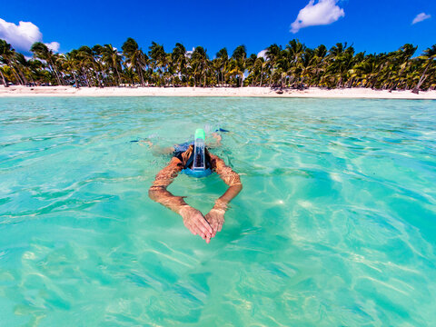 Woman swimming in turquoise sea water at exotic beach
