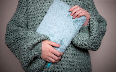 Close-up of a woman's hand holding a fluffy notebook. Warm knitted sweater