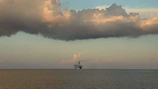 A cruise ship sailing off the coast of Sicily, Italy into the sunset.