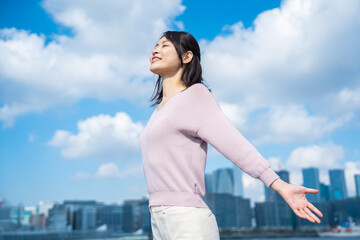 外で深呼吸をする若いビジネスウーマン