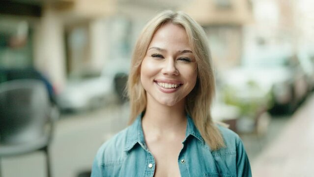 Young blonde woman smiling confident standing at street