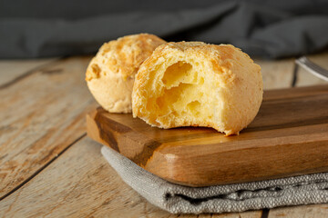 pão de queijo, a traditional brazilian food made of chesse bread, over wooden table and cutting board