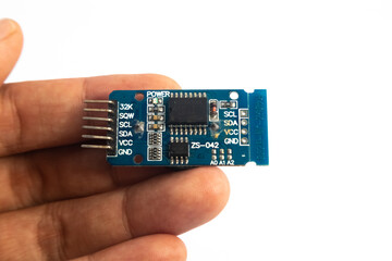 A ZS-042 RTC (Real Time Clock) module held in hand. This module is used for electronics hobbyists...