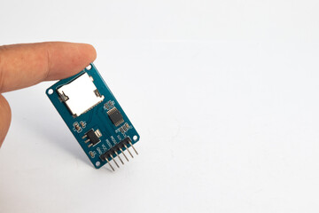 A microSD card reader module held by a finger. This module is used for electronics hobbyists for DIY materials.