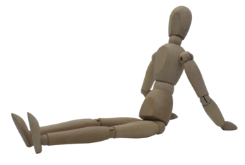 Wooden jointed figure sitting on ground with legs stretched out and hands on ground behind