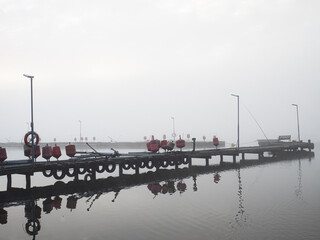 Empty pier on a foggy misty autumn day
