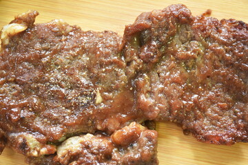 grilled beef steak dressing barbecue sauce  with French fries and salad on chopping block in white background 