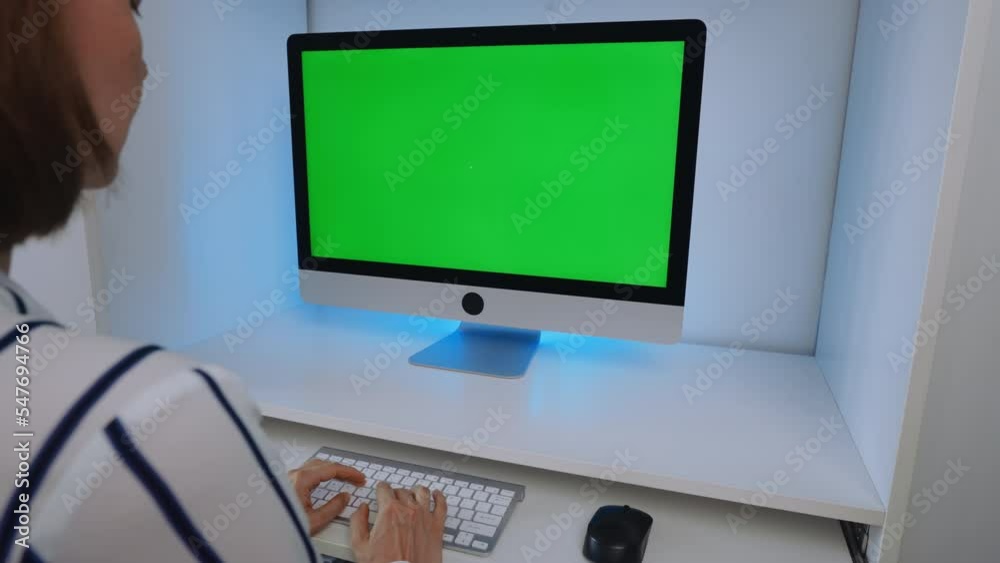 Poster businesswoman sitting at workplace looking on display computer with green screen typing on keyboard