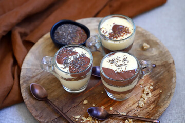 Healthy desserts in mugs. Vanilla and chocolate puddings with chia seeds and linseeds.