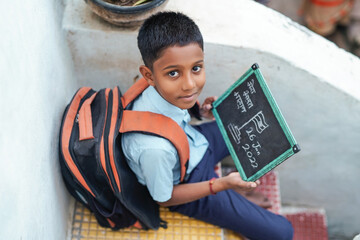 Indian child writing or holding Chalkboard