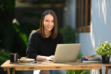 Fototapeta premium Canadian caucasian woman sitting outdoor coffee shop and looking at camera