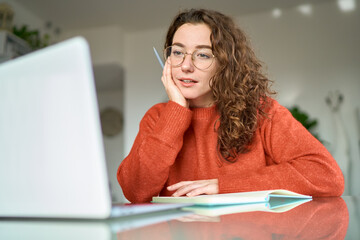 Young pretty woman student using laptop elearning or remote working at home office using laptop...