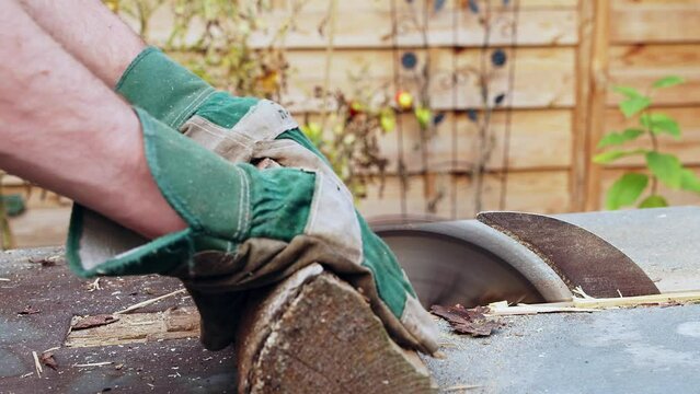 Brennholz wird mit einer Kreiss&auml;ge in kleine Scheite ges&auml;gt.