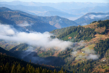 Aerial landscape photo of mountains covered with light fog. Picturesque view from above.