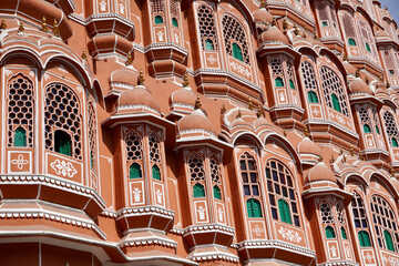 Fototapeta na wymiar Hawa Mahal palace Jaipur, India. Facade of the palace of winds. Five floor exterior built like honeycomb with small windows decorated with intricate latticework.