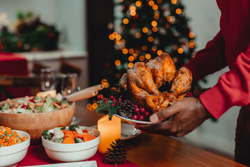 A man is carrying christmas turkey dinner ready to be eaten in his hand.