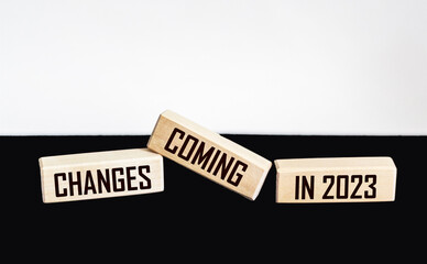 Wooden blocks with the words the word Changes is coming in 2023 on a black and white background