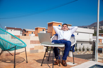 Adult businessman using laptop and phone