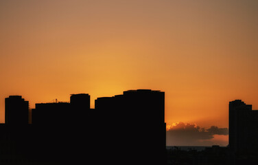 Fototapeta premium Orange and Black Cityscape Silhouette at Sunset.
