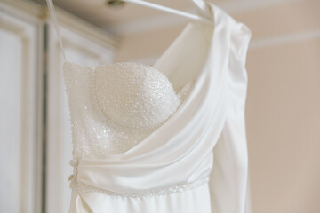 Fees for the wedding of a beautiful luxurious bride in a bathrobe with a wedding dress in a hotel, fashion portraits