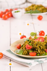 Fusilli pasta with cherry tomatoes and peas.