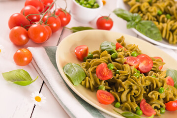Fusilli pasta with cherry tomatoes and peas.