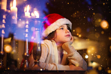 Beautiful Little girl looking for Santa in window