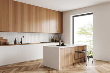 Light kitchen interior with bar countertop and seats near window, cooking space