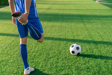 football soccer player stretching during warm up before kick ball in football match league in stadium with healthy sport concept