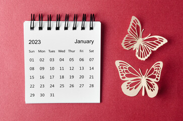A January 2023 desk calendar for the organizer to plan and reminder with paer butterfly on red background.