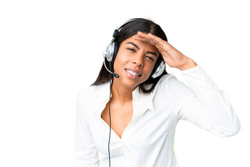 Telemarketer African American woman working with a headset over isolated chroma key background looking far away with hand to look something