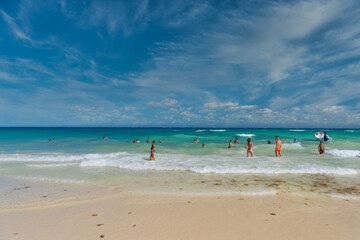 Fototapeta na wymiar PLAYA DEL CARMEN, MEXICO - APR 2022: Sexy girl in string tanga bikini on the beach on a sunny day in Playa del Carmen, Yukatan, Mexico