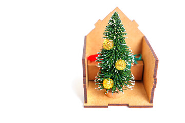 Christmas tree and presents in toy house on white